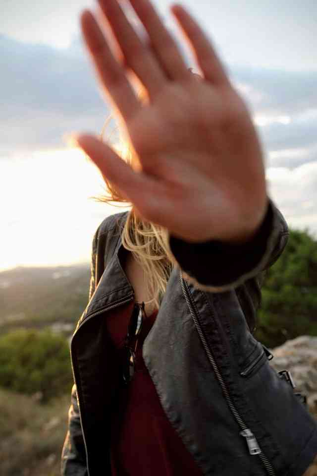 woman with hand over camera